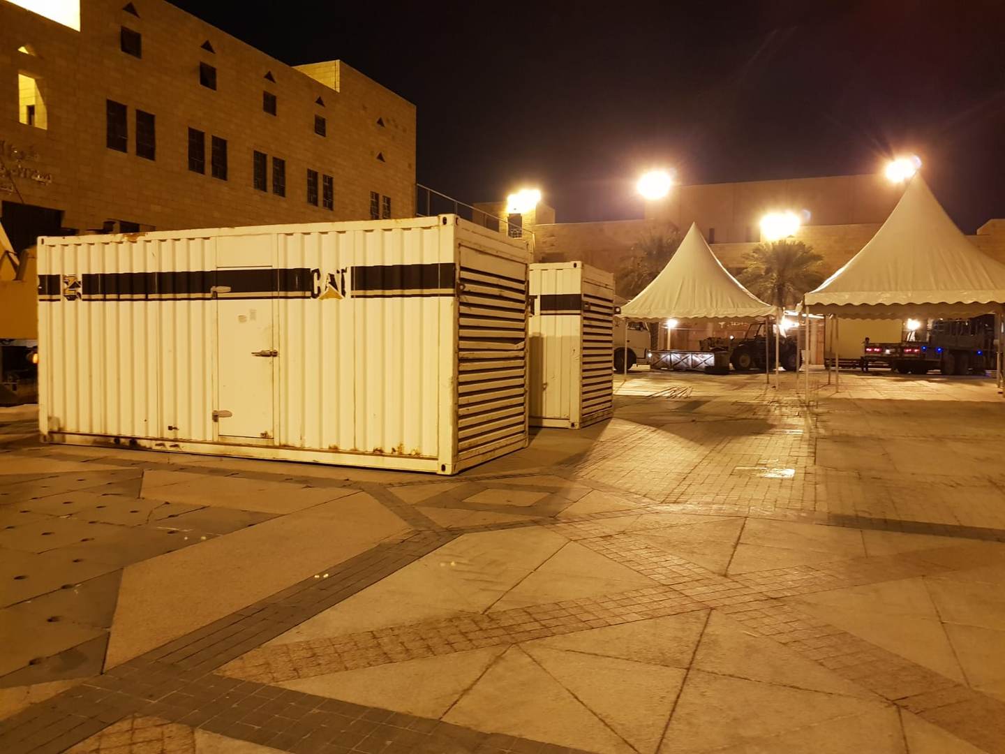 CAT generator containers installed near event tents at night
